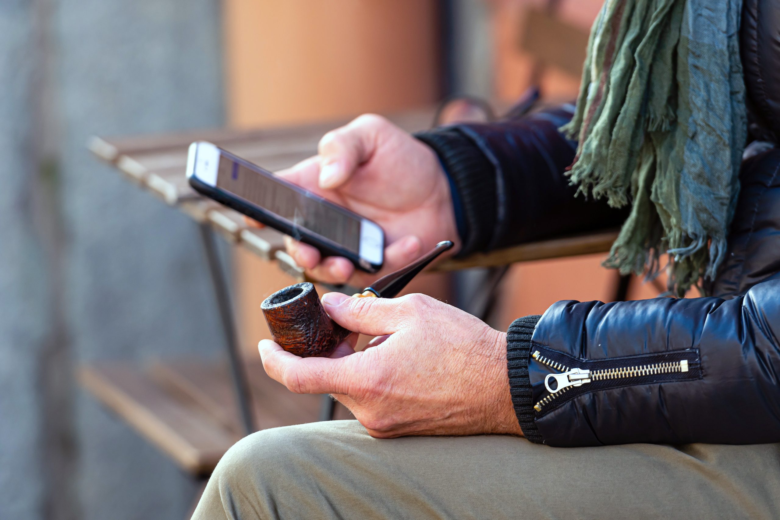 smoking pipe and smartphone in male hands buraliste utilisant les réseaux sociaux en action